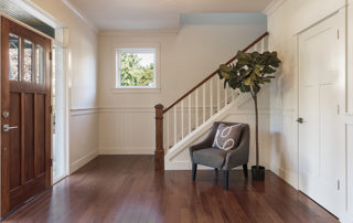Armchair and potted tree in house entryway