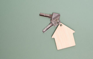 Keychain in form house with keys on green background