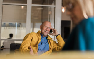 Close-up of a calm phone call with notes and a contract on a table, suggesting clear, professional communication during a real estate transaction.